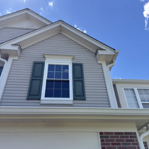 New double-hung window with white trim installed on the front of a Naperville home.